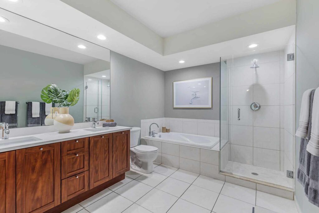 Bathroom with toilet, tub, and walk in glass shower