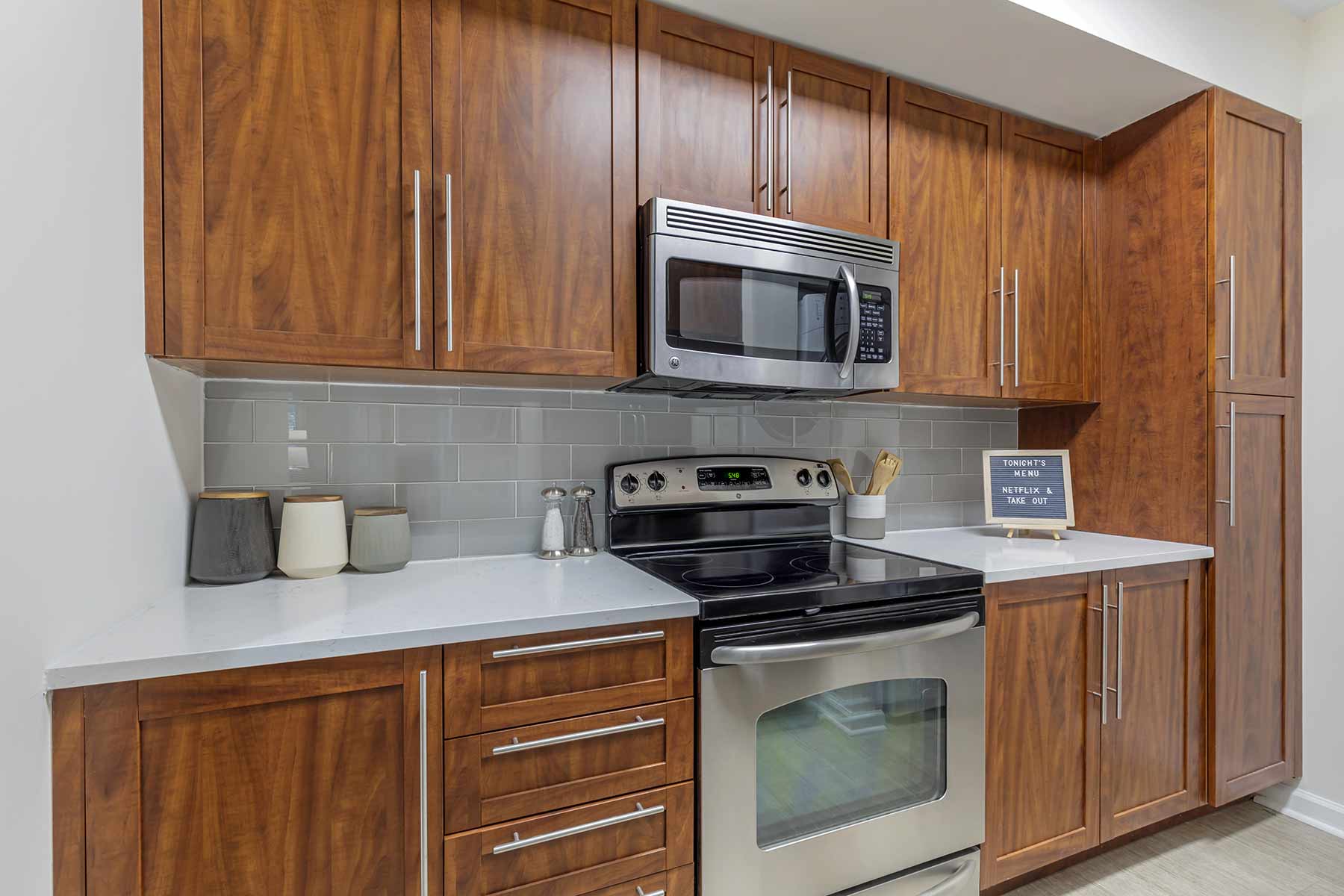 Kitchen with stainless steel appliances, white counters, and tile backsplash