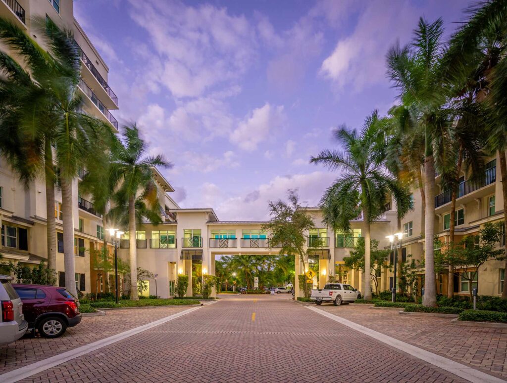 Building exterior showing large trees and lots of balconies