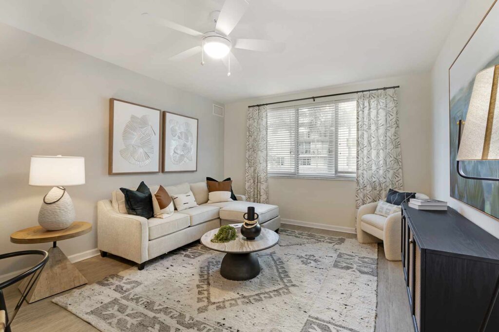 Living room with ceiling fan and large windows