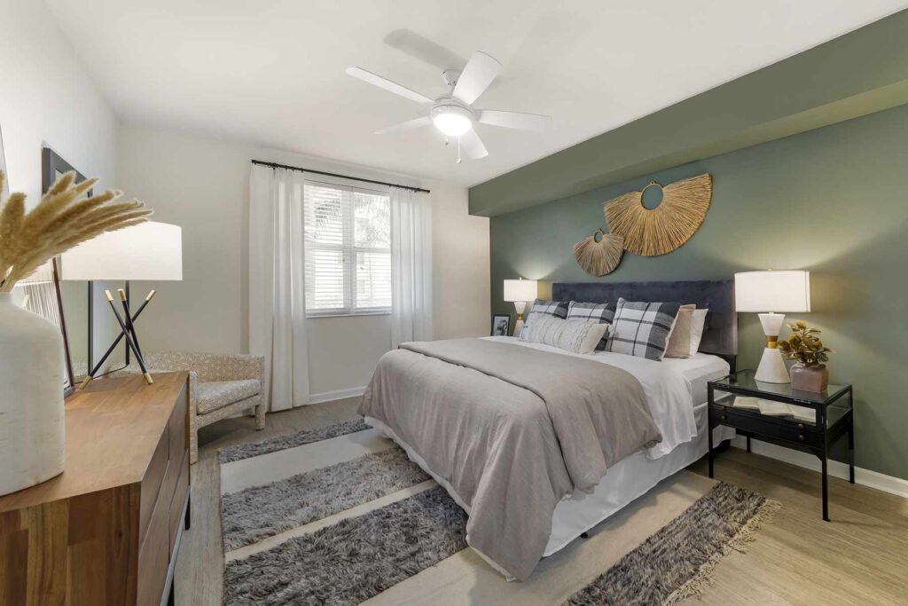 Bedroom with ceiling fan and green accent wall