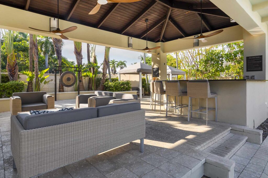 Covered grilling pavilion by the pool with lounge seating