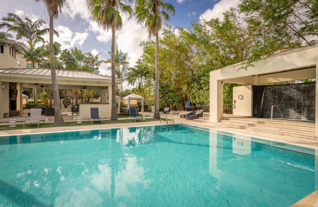 Pool with deck seating, covered cabanas, and covered pavilion