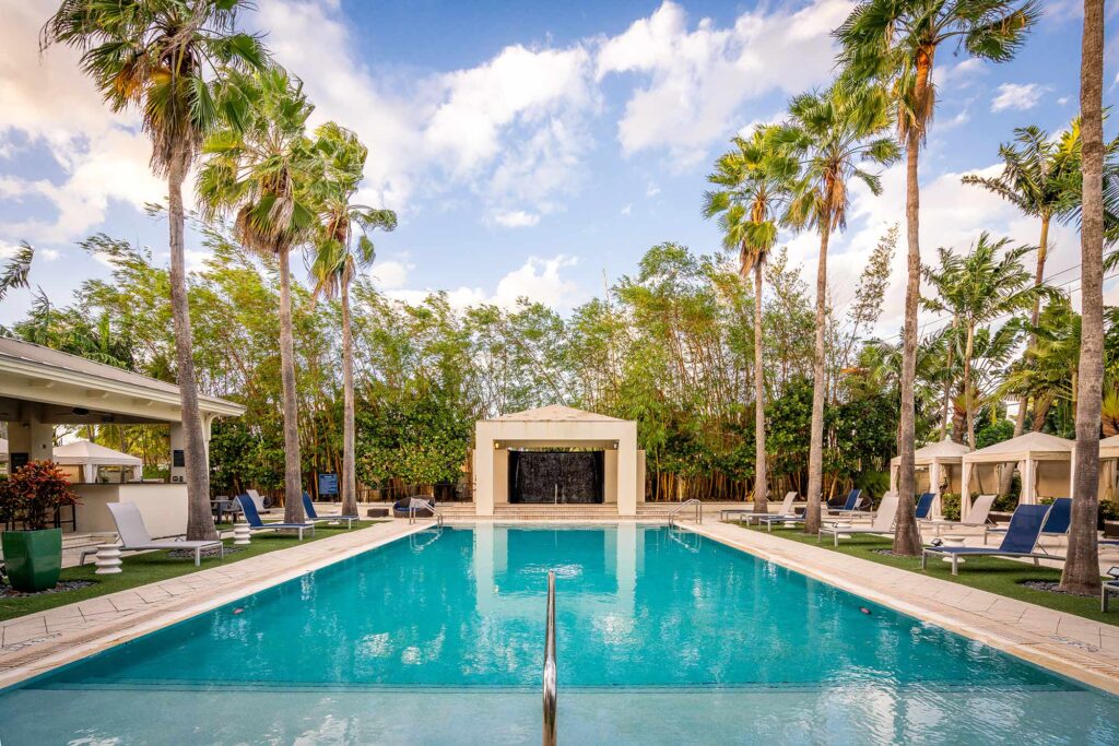 Pool with deck seating, covered cabanas, and covered pavilion