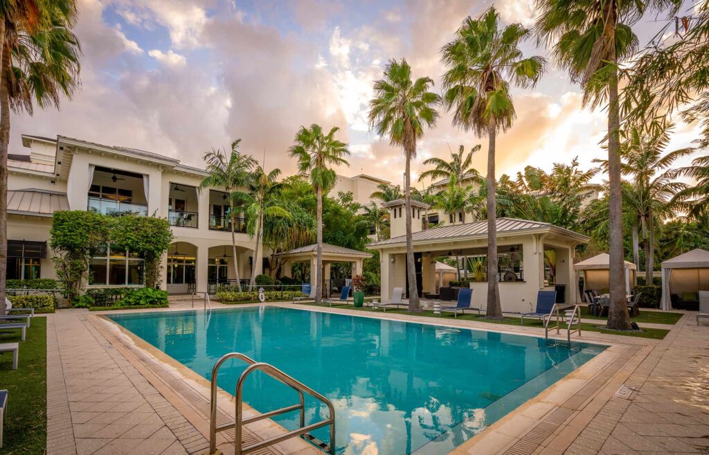 Pool with deck seating, covered cabanas, and covered pavilion