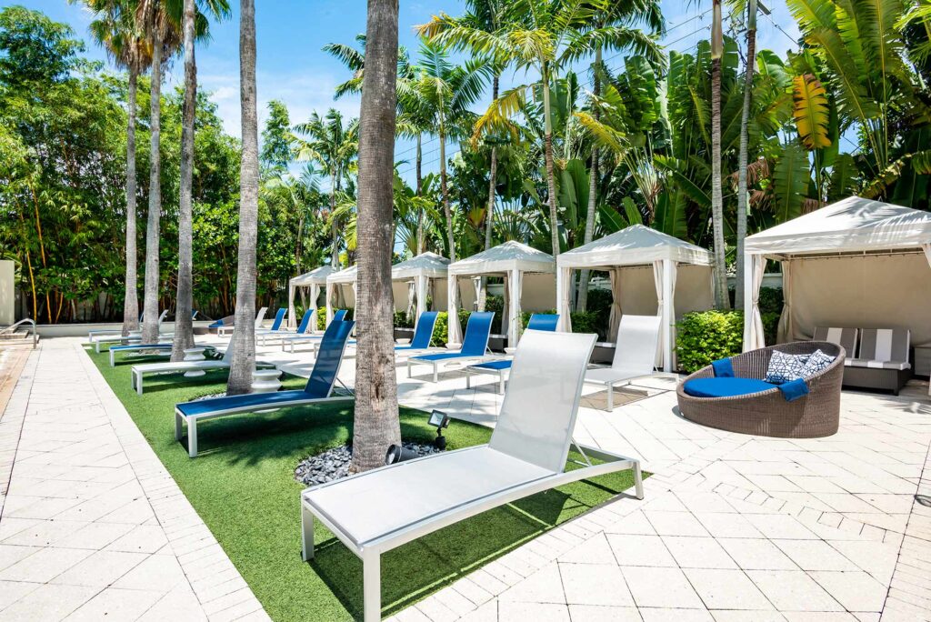 Pool with deck seating, covered cabanas, and covered pavilion
