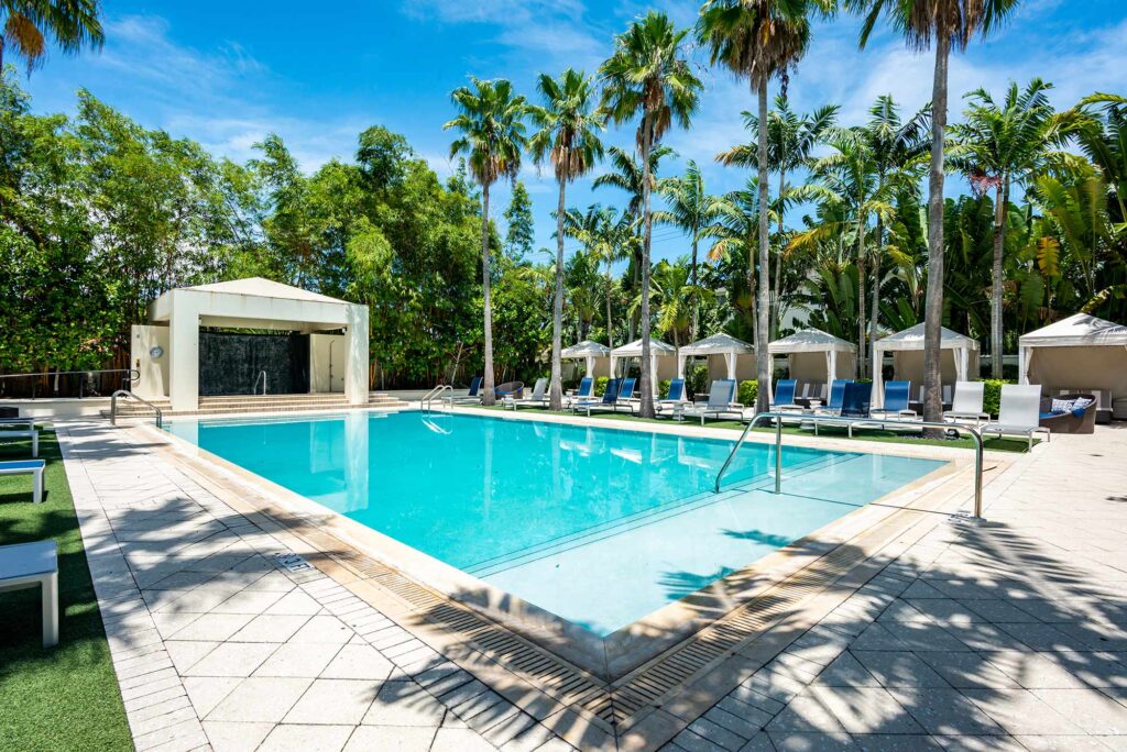 Pool with deck seating, covered cabanas, and covered pavilion
