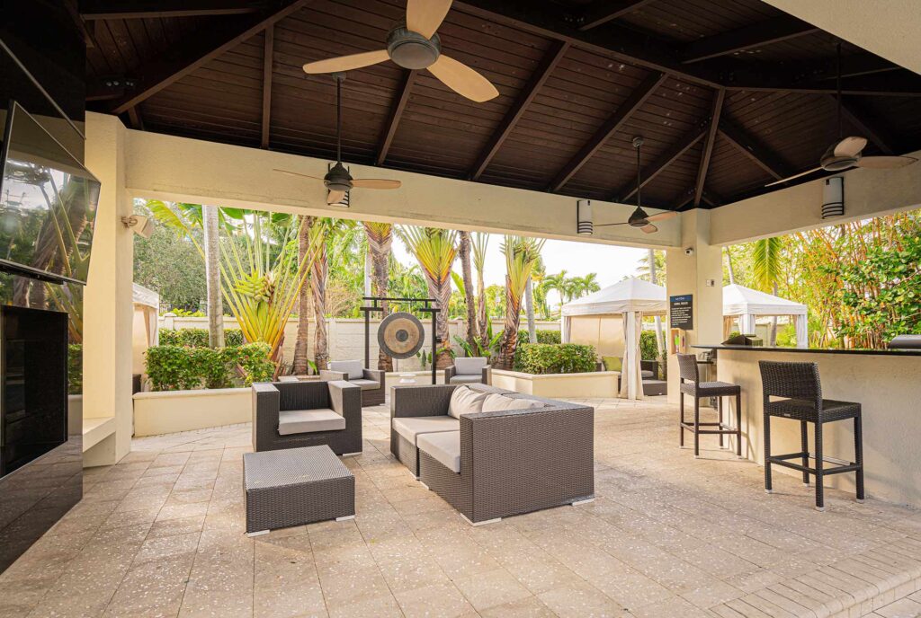 Covered grilling pavilion by the pool with lounge seating