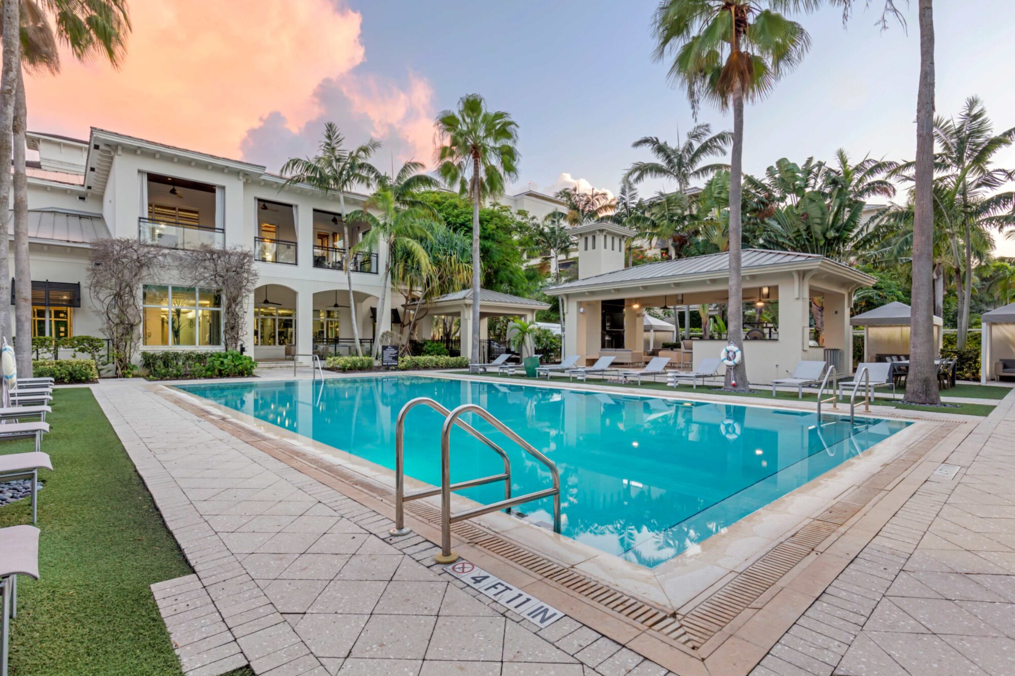 Pool with deck seating, covered cabanas, and covered pavilion